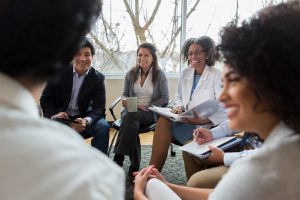 A group of smartly dressed people sitting together in a circle