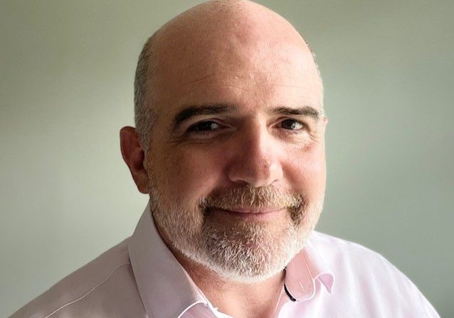 Photo of a man with a short goatee and moustache and shaved head